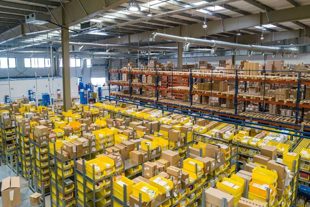 Large organised warehouse filled with boxed stock and storage racks